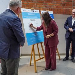 Starosta Aleksandrowski Lidia Tokarska składa podpis na pamiątkowej tablicy z sygnatariuszamy umowy partnrskiej