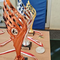 zdjęcie przedstawia medale i puchary dla zawodników